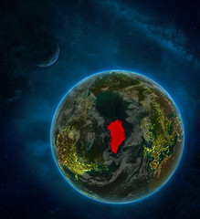 Greenland from space on Earth at night surrounded by space with Moon and Milky Way. Detailed planet with city lights and clouds.