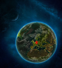 Germany from space on Earth at night surrounded by space with Moon and Milky Way. Detailed planet with city lights and clouds.