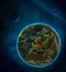 Poland from space on Earth at night surrounded by space with Moon and Milky Way. Detailed planet with city lights and clouds.