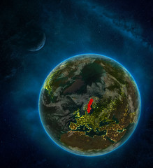 Sweden from space on Earth at night surrounded by space with Moon and Milky Way. Detailed planet with city lights and clouds.