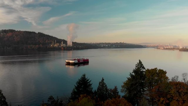 An aerial shot of a barge in Burrard Inlet with the Parkland oil refinery and downtown Vancouver in the background.