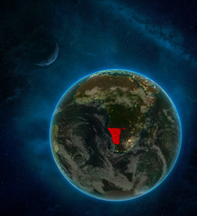Namibia from space on Earth at night surrounded by space with Moon and Milky Way. Detailed planet with city lights and clouds.