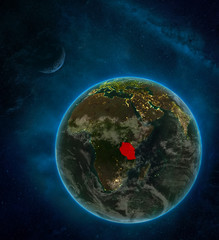 Tanzania from space on Earth at night surrounded by space with Moon and Milky Way. Detailed planet with city lights and clouds.