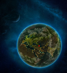 Azerbaijan from space on Earth at night surrounded by space with Moon and Milky Way. Detailed planet with city lights and clouds.