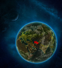 Turkmenistan from space on Earth at night surrounded by space with Moon and Milky Way. Detailed planet with city lights and clouds.