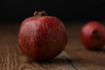 Beautiful composition with juicy pomegranates, on old wooden table