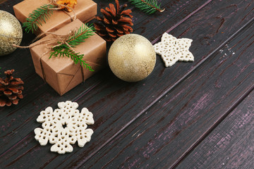 Christmas composition. Christmas gift, knitted blanket, pine cones, fir branches on wooden background.