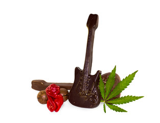 Idea concept background of Sex, drugs, rock and roll. Chilli Willy pepper as sex, chocolate as rock music and hemp leaf as drug on white background. The ideals of modern subculture