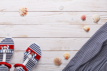 Travel vacation concept with sandals, seashells and striped t-shirt. Top view with copy space