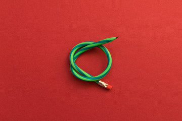 Flexible pencil . Isolated red background