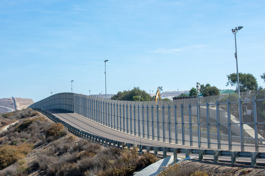 The Secured Border Fence And Road For United States Border Patrol Vehicles On The US - Mexico International Border In California