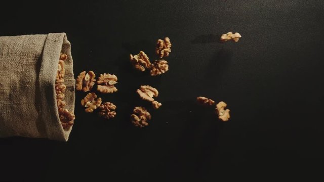 TOP VIEW: Bag falls and peeled walnuts are poured out of it - Slow Motion