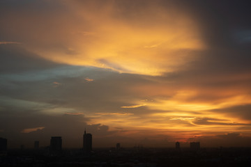 Golden sunset of cloudy sky over the city.