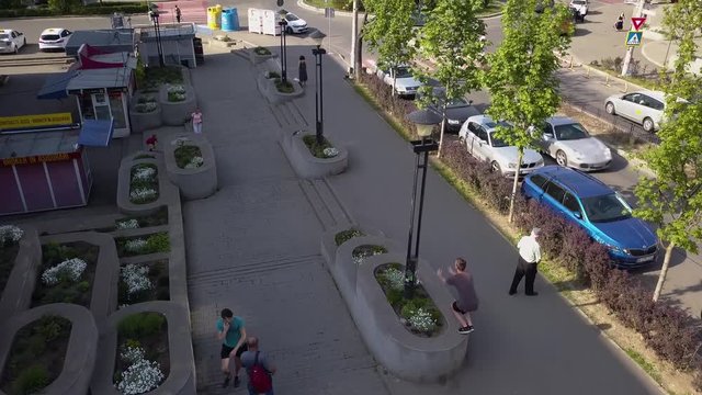 Aerial Drone Tracking Shot of a Young Adult Male Dare Devil Jumping and Flipping through a Crowded Downtown Area.