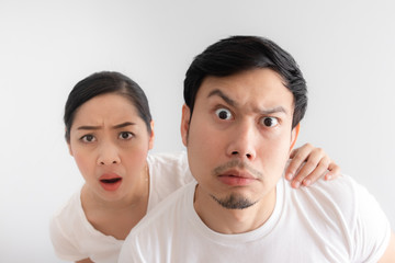Funny face of lovers couple in doubt at an unbelievable thing that they are looking at