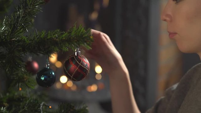 girl decorate Christmas tree in a house. holiday celebration. season's greetings