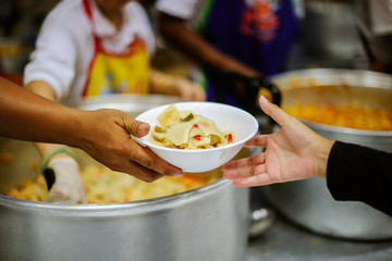 Poor people receive donated food from donors, Demonstrate mutual sharing in today's society : the concept of helping the needy