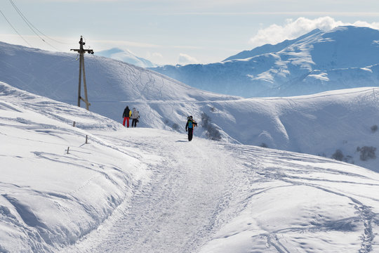 Skiers and snowboarders go on snow road