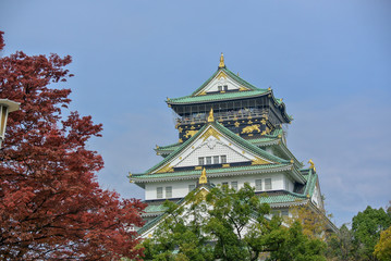 Osaka castle tower in japan, in Autumn, maple leaf colour change, very beautiful design on architecture