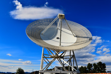 Array of satellite dishes or radio antennas against sky. Space o