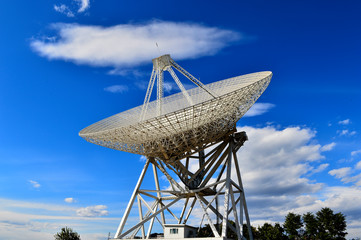 Array of satellite dishes or radio antennas against sky. Space o