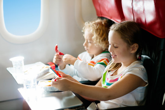 Child In Airplane. Kids Fly. Children Flight Meal