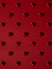 Christmas ornament with glass balls with hard shadows on red background