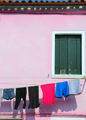 clothes hang out to dry outside a pink house