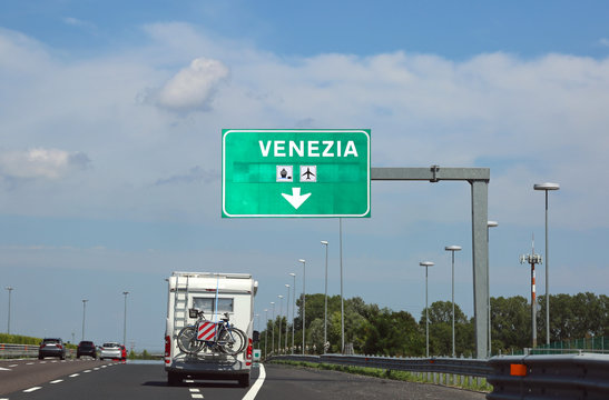 road sign indicating Venice and a camper on the road