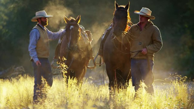 Cowboys with horses in forest wilderness area Canada