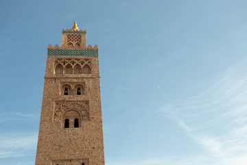 Fototapeta na wymiar Koutoubia Mosque minaret (Djemma el Fna tower) in old medina of Marrakech, Morocco. Touristic place in Marrakesh used by local people as square or market place. 