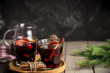 Christmas composition with spicy mulled wine and pine cones on wooden background