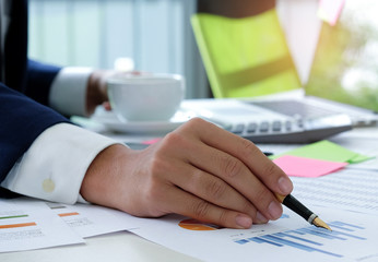 Office staff with pen and coffee in hand.