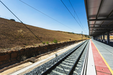 Railway line, deserted train station, empty platform, beautiful blue sky