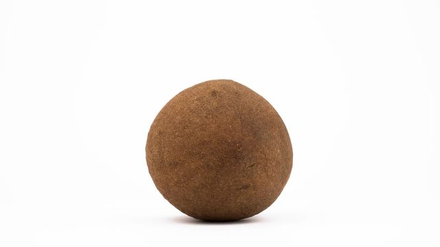 One whole mammea americana apple fruit. Rotating on the turntable. Isolated on the white background. Close-up. Macro.