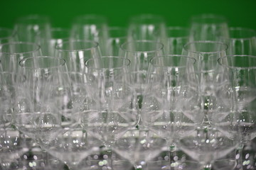 Shiny wine glasses in front of a green background.