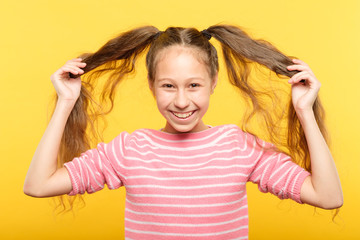 happy joyful smiling adolescent girl showing her pig tails relaxed carefree lifestyle and childish behavior.