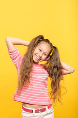 happy smiling pretty little girl. carefree child portrait on yellow background. emotional facial expression.