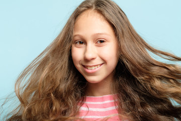 smiling content girl with hair flying in the wind. haircare product and beauty and health.