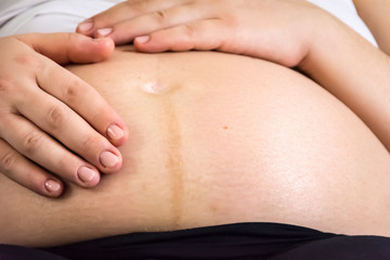 Hands of a pregnant woman caressing her belly