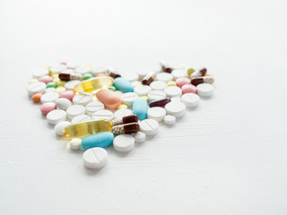 pills mix in a heart shape. painkillers and prescription drugs on white background