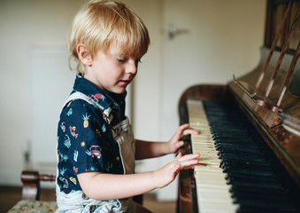 Young boy playing a piano © Rawpixel.com