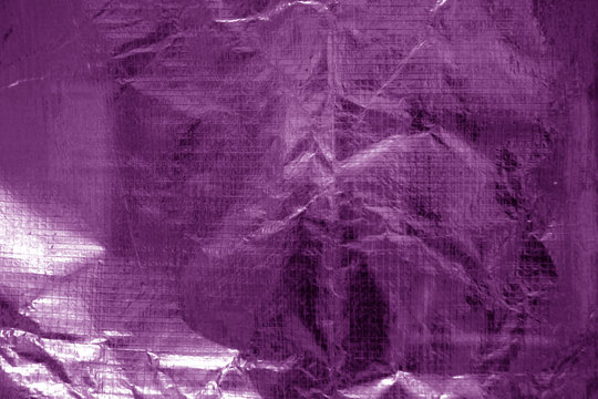 Crumpled transparent plastic  surface in purple color.