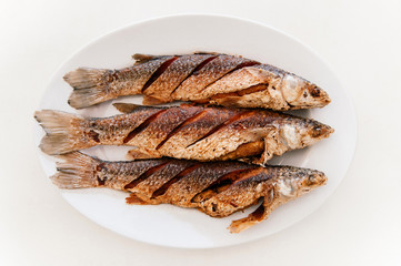 Thai style deep fried fishes on white plate, Top view