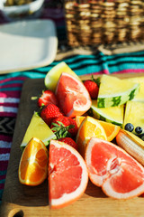 Fresh fruits on a wooden board at a picnic