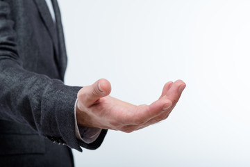 business man holding invisible object in palm of hand. empty space for advertising.