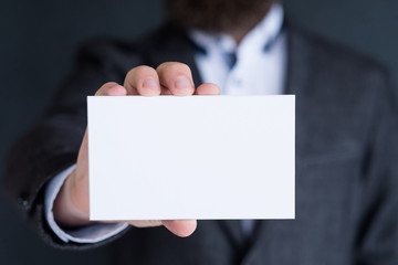 man holding blank white paper. information business card. empty space for advertisement.