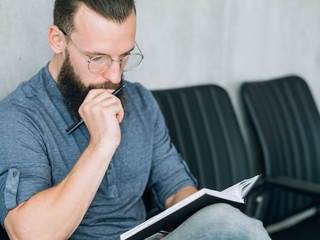 Naklejka premium focused concentrated man reading notes in notepad. data analysis or business strategy development.