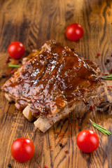 Delicious barbecued ribs seasoned with a spicy basting sauce and served with chopped fresh...