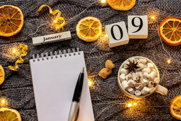 calendar January 9th Cup of cocoa and empty open notepad